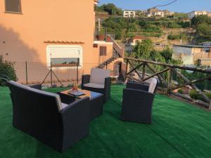 a patio with chairs and a table on a green lawn at Milordrelais in Massa Lubrense