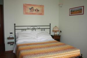 1 dormitorio con 1 cama con manta a rayas en B&B CASA DEL BOSCHETTO, en Torriana