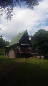 uma casa com um telhado verde com um deque em Chata Dolce I em Trutnov