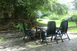 drie stoelen en een tafel in een tuin bij Casa Papa in Friedberg