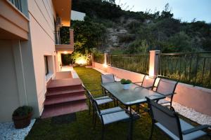 a patio with a table and chairs on a balcony at Searockhouse in Paleo Tsifliki