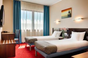 a hotel room with two beds and a window at Focus Hotel Gdańsk in Gdańsk