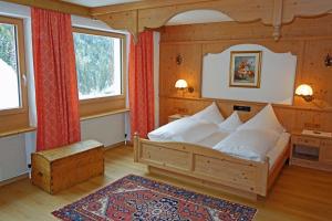 a bedroom with a bed and two windows at Alkira in Sankt Anton am Arlberg