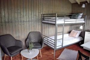 a room with two bunk beds and two chairs at Solbakken Cabins in Geiranger