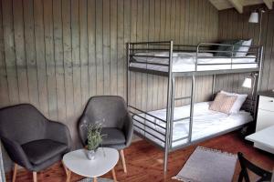 Habitación con 2 literas y 2 sillas en Solbakken Cabins en Geiranger