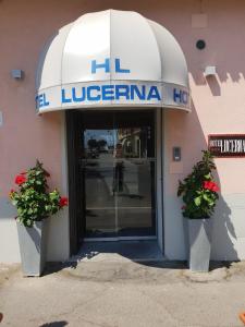 a entrance to a library with two plants in front of a building at Hotel Lucerna in Castiglione della Pescaia