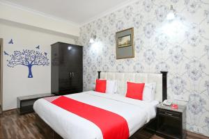 a bedroom with a large bed with red pillows at Akashdeep 22 in Chandīgarh