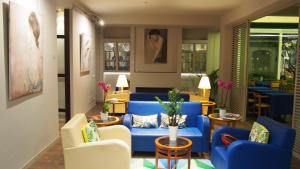 una sala de estar con sofás y sillas azules en Hotel Lucerna, en Castiglione della Pescaia