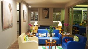 a living room with blue couches and chairs at Hotel Lucerna in Castiglione della Pescaia