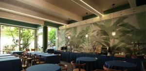 a dining room with blue tables and chairs at Hotel Lucerna in Castiglione della Pescaia