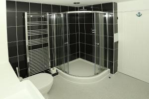 une salle de bain avec toilettes et douche en verre dans l'établissement Lazy Days Cottage, à Winterton-on-Sea 47 autres photos