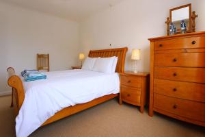 une chambre avec un grand lit avec une commode et une commode dans l'établissement Lazy Days Cottage, à Winterton-on-Sea