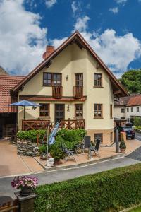 ein Haus mit einer Terrasse und Stühlen davor in der Unterkunft Ferienappartement Balik in Bad Staffelstein