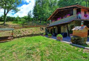 a house with a building with a grass yard at Villa Margherita by PosarelliVillas in Piegaio