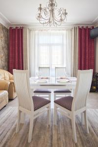 a dining room with a white table and chairs at Studiominsk 9 Apartments in Minsk