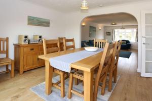 een keuken en eetkamer met een houten tafel en stoelen bij Lazy Days Cottage in Winterton-on-Sea