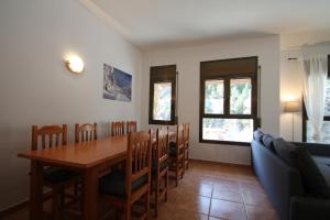 a dining room with a table and chairs and a couch at Pont de Toneta 4,1 Ransol, Zona Grandvalira in Ransol