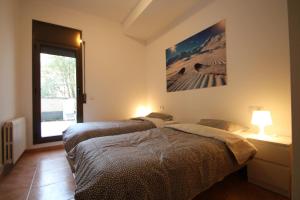 two beds in a room with a window at Pont de Toneta 4,1 Ransol, Zona Grandvalira in Ransol