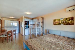 a bedroom with a bed and a table and a dining room at ДриймБг Апартаменти - Панорама Бийч, Несебър in Nesebar