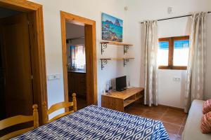 a bedroom with a bed and a desk with a computer at Ca Na Maria Teueta in San Ferrán de ses Roques