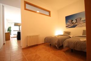 a room with two beds and a table in it at Pont de Toneta 4,2 Ransol, Zona Grandvalira in Ransol