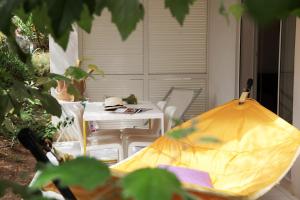 eine Terrasse mit einem Tisch und einem gelben Sonnenschirm in der Unterkunft Résidence Le Clos Saint Paul in LʼÎle-Rousse