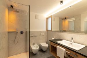 a bathroom with a sink and a toilet and a shower at Hotel Eller in Solda