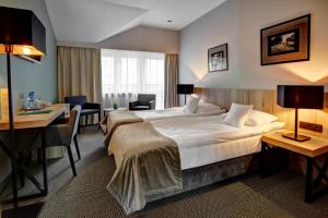 pokój hotelowy z dużym łóżkiem i biurkiem w obiekcie Hotel Wojciech w mieście Augustów