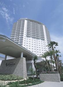a large white building with palm trees in front of it at Hotel Emion Tokyo Bay in Tokyo