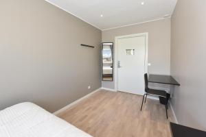 a bedroom with a desk and a bed and a table at Måby Park & Hotell in Arlanda