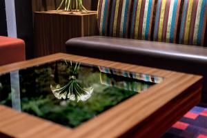 a coffee table with a plant on it next to a couch at the b akasaka in Tokyo
