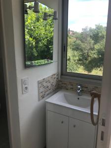 a bathroom with a sink and a window at Appartements La Fossette plage in Le Lavandou