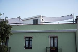 una casa blanca con una bandera encima en Green House en Villaputzu