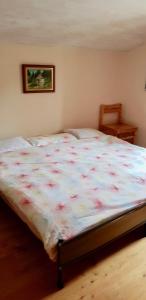 een slaapkamer met een groot bed en een bloemrijke deken bij La Bola in Roveredo