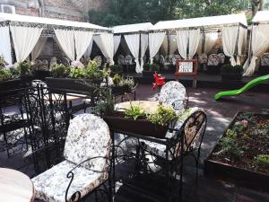 a patio with tables and chairs with potted plants at Hotel Neptun in Vidin