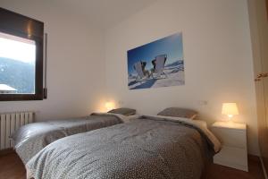 - 2 lits dans une chambre avec une photo sur le mur dans l'établissement Pont de Toneta 4,4 Ransol, Zona Grandvalira, à Ransol