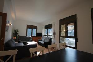 a living room with a couch and a table and chairs at Pont de Toneta 4,4 Ransol, Zona Grandvalira in Ransol