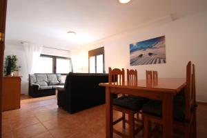 sala de estar con mesa y sofá en Pont de Toneta 5,1 Ransol, Zona Grandvalira, en Ransol