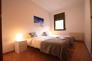 a bedroom with a bed and a nightstand and a window at Pont de Toneta 5,1 Ransol, Zona Grandvalira in Ransol