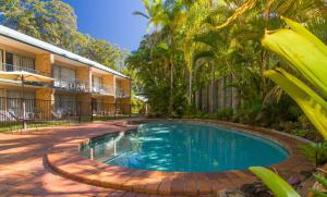 Sunshine Coast Motor Lodge في Woombye: مسبح امام مبنى