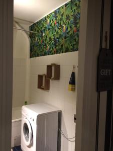 a washing machine in a bathroom with a painting on the wall at Bakia in Biarritz