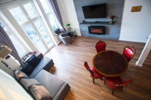 a living room with a table and a couch and a fireplace at Apartament EC1 Łódź Fabryczna in Łódź