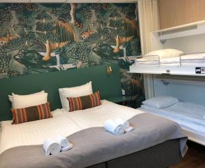 1 dormitorio con 2 camas y toallas. en Kom Family en Estocolmo