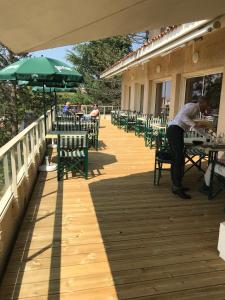 a man sitting at a table on a deck at Logis Hôtel de la Bruyere in Pouzauges