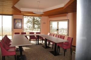 a conference room with a long table and red chairs at Logis Hôtel de la Bruyere in Pouzauges