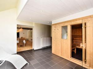 a living room with a wooden door and a table at Fine group house with sauna garden in Chiny