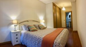 1 dormitorio con 1 cama y 1 lámpara en una mesa en Apartamento Europa Jardín, en Oviedo