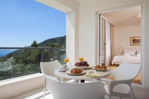 a dining room with a table and chairs and a large window at Villa Lukić in Makarska