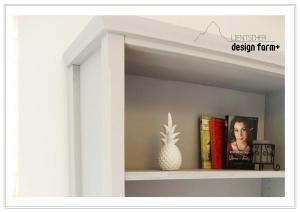 a shelf with books and a pineapple on it at Lientscher design farm in Eisentratten