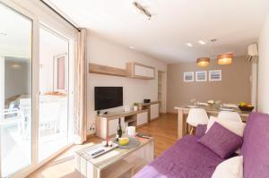 a living room with a purple couch and a table at Park Lein in Lloret de Mar